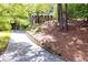 Long driveway leading to a brick home surrounded by lush greenery and mature trees at 535 Silver Pine Trl, Roswell, GA 30076