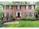 Charming brick home featuring black shutters, a manicured lawn, and lush landscaping at 535 Silver Pine Trl, Roswell, GA 30076