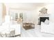Spacious living room with a fireplace, ample seating, and a view into the sunroom through french doors at 535 Silver Pine Trl, Roswell, GA 30076