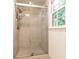 Tiled shower with glass door and modern fixtures next to a window at 535 Silver Pine Trl, Roswell, GA 30076