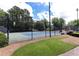 Outdoor tennis courts with a dark fence, light blue courts, and scattered trees nearby at 535 Silver Pine Trl, Roswell, GA 30076
