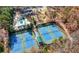 Aerial view showcases the community tennis courts alongside a pool and clubhouse, all surrounded by mature trees at 4615 Kilmersdon Ln, Suwanee, GA 30024