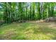 Secluded backyard surrounded by lush greenery, offering a tranquil outdoor retreat, and a wooden deck at 4882 Rock Haven Sw Dr, Lilburn, GA 30047