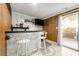 Charming bar area with white stools, dark countertop, and a sliding glass door to the outdoor patio at 4882 Rock Haven Sw Dr, Lilburn, GA 30047