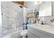 Bright bathroom with white marble-style tile, shower-tub combination, and modern vanity at 4882 Rock Haven Sw Dr, Lilburn, GA 30047