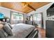 Cozy bedroom with wood ceiling, soft lighting, hardwood floors, and large windows with decorative curtains at 4882 Rock Haven Sw Dr, Lilburn, GA 30047