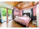 Charming bedroom with pink walls, hardwood floors, and sliding glass doors leading to a backyard at 4882 Rock Haven Sw Dr, Lilburn, GA 30047