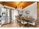Dining area with a wooden ceiling, hardwood floors, a modern chandelier, and stainless steel refrigerator at 4882 Rock Haven Sw Dr, Lilburn, GA 30047