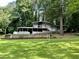 Charming home with a carport and white trim, surrounded by a lush green lawn and mature trees at 4882 Rock Haven Sw Dr, Lilburn, GA 30047
