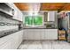 Bright kitchen featuring white cabinets, black countertops, and mosaic tile backsplash at 4882 Rock Haven Sw Dr, Lilburn, GA 30047