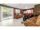 Comfortable living room with brick accent wall, wood paneling, and access to the backyard via sliding doors at 4882 Rock Haven Sw Dr, Lilburn, GA 30047