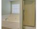 Bathroom featuring bathtub with tile surround and glass shower at 116 Laurel Ln, Social Circle, GA 30025
