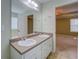 Bathroom featuring dual sinks, vanity and a doorway to a bedroom at 116 Laurel Ln, Social Circle, GA 30025