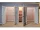 Bedroom features three open closets with built in shelving and hanger bars at 116 Laurel Ln, Social Circle, GA 30025