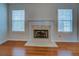 Close-up of a fireplace with a marble hearth and white mantel in a sunlit living room at 116 Laurel Ln, Social Circle, GA 30025