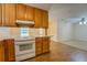 Kitchen with wood cabinets, countertop bar with view to the carpeted living room at 116 Laurel Ln, Social Circle, GA 30025