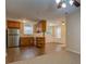 Kitchen with wood cabinets, laminate flooring, and view of living room and front entrance at 116 Laurel Ln, Social Circle, GA 30025