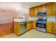 Kitchen area showcasing stainless steel appliances, wood cabinets, an adjacent living area, and natural light at 116 Laurel Ln, Social Circle, GA 30025