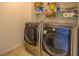 Laundry room with modern front load washer and dryer on vinyl flooring with shelving for storage at 116 Laurel Ln, Social Circle, GA 30025