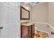 Charming half-bathroom with decorative tiled floor, elegant vanity, framed mirror, and white door at 362 Interlake Pass, Mcdonough, GA 30252
