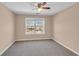 Bedroom with neutral carpet, ceiling fan, and a large window with a neighborhood view at 362 Interlake Pass, Mcdonough, GA 30252