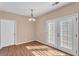 Dining area with hardwood-style floors, modern light fixture, and glass-paneled doors to the backyard at 362 Interlake Pass, Mcdonough, GA 30252