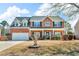Charming two-story red brick home with a well-manicured lawn and attached two-car garage at 362 Interlake Pass, Mcdonough, GA 30252