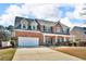 Traditional two-story brick home featuring a covered front porch and attached two-car garage at 362 Interlake Pass, Mcdonough, GA 30252