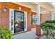 Close-up of the front door and covered porch, featuring brick columns and manicured landscaping at 362 Interlake Pass, Mcdonough, GA 30252
