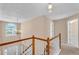 Upstairs hallway with natural light, chandelier, wooden railings, and access to rooms at 362 Interlake Pass, Mcdonough, GA 30252