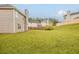 Large, grassy backyard is enclosed by a wooden fence; view includes surrounding homes and trees at 4139 Kensington Cv, Atlanta, GA 30349