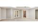 Finished basement with double glass doors to backyard, featuring light colored wood-look floors and neutral walls at 415 Collegiate Dr, Powder Springs, GA 30127