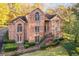 Two story brick home with manicured lawn and garden areas leading to a brick steps and a covered entrance at 415 Collegiate Dr, Powder Springs, GA 30127