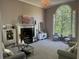 Bright living room with large arched window, fireplace, neutral décor, and comfortable seating at 415 Collegiate Dr, Powder Springs, GA 30127