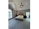 Spacious main bedroom with vaulted ceilings, chandelier, neutral colors, and large windows at 415 Collegiate Dr, Powder Springs, GA 30127
