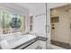 Elegant bathroom features a soaking tub under a decorative window, plus a glass-enclosed shower at 1020 Riverside Rd, Roswell, GA 30076