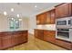 A modern kitchen with stainless steel appliances, wood cabinets and hardwood floors at 1020 Riverside Rd, Roswell, GA 30076