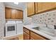 Laundry room featuring a sink, washer and dryer, and cabinets with butterfly wallpaper at 1020 Riverside Rd, Roswell, GA 30076