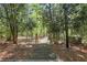 Wood pathway leading through a lush, wooded area with mature trees and landscaping at 1020 Riverside Rd, Roswell, GA 30076