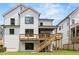 Backyard featuring a deck with stairs leading to a stone patio and manicured lawn, perfect for outdoor living at 267 Green Hill Rd, Sandy Springs, GA 30042