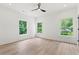 Sunlit bedroom with large windows overlooking lush greenery and a modern ceiling fan for comfort at 267 Green Hill Rd, Sandy Springs, GA 30042