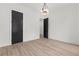 Bedroom with a sleek black door, light wood flooring, and a modern chandelier at 267 Green Hill Rd, Sandy Springs, GA 30042