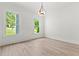 Sunlit bedroom with light wood floors, two windows, and a modern ceiling light at 267 Green Hill Rd, Sandy Springs, GA 30042
