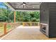 Covered wood deck featuring an outdoor fireplace and backyard view at 267 Green Hill Rd, Sandy Springs, GA 30042