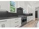 Modern kitchen featuring white cabinetry, stone countertops, and stainless steel appliances at 267 Green Hill Rd, Sandy Springs, GA 30042