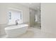 Luxurious bathroom features a modern soaking tub and walk-in shower with glass surround, illuminated by natural light at 267 Green Hill Rd, Sandy Springs, GA 30042