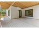 View of covered patio with concrete flooring, black door and windows, and wood beam ceilings at 267 Green Hill Rd, Sandy Springs, GA 30042