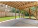 View of the home's covered patio, outdoor stairs, and spacious backyard with mature trees and a wooden fence at 267 Green Hill Rd, Sandy Springs, GA 30042