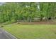 View of a charming home nestled among mature trees, with a well-maintained lawn in a quiet neighborhood at 408 Walnut Dr, Woodstock, GA 30189