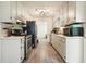 Galley kitchen with white cabinets, stainless appliances, and vinyl floors at 408 Walnut Dr, Woodstock, GA 30189